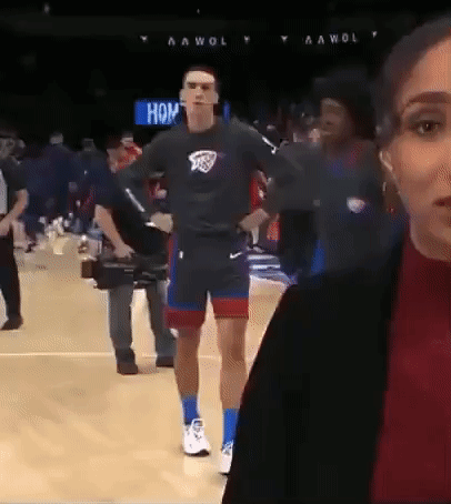 A Man Is Walking On A Basketball Court While A Woman Looks On GIF
