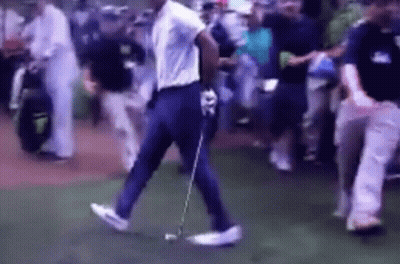 A Man Is Walking On A Golf Course With A Golf Club GIF