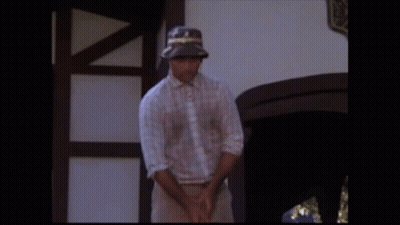 A Man Is Walking Through A Garden Of Flowers GIF