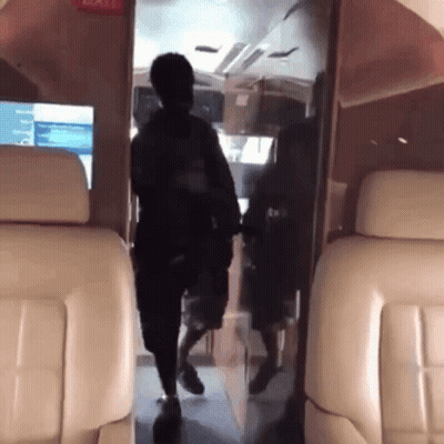 A Man Is Walking Through The Door Of A Plane GIF