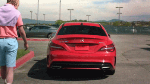 A Man Is Walking Towards A Red Mercedes Benz Car GIF