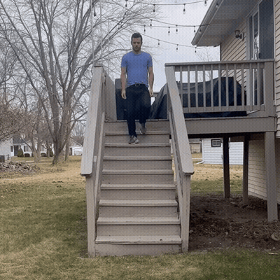 A Man Is Walking Up A Set Of Stairs GIF