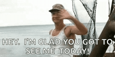 A Man Is Waving At The Camera While Standing On A Boat . GIF