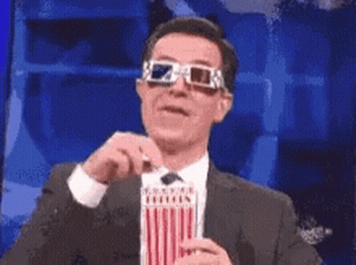 A Man Is Wearing 3D Glasses And Holding A Popcorn Box GIF