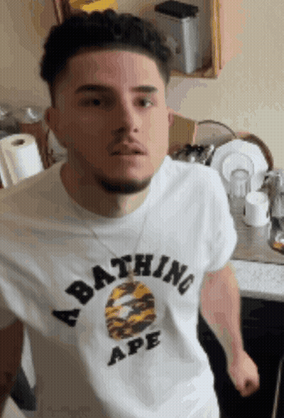 A Man Is Wearing A Bathing Ape Shirt GIF