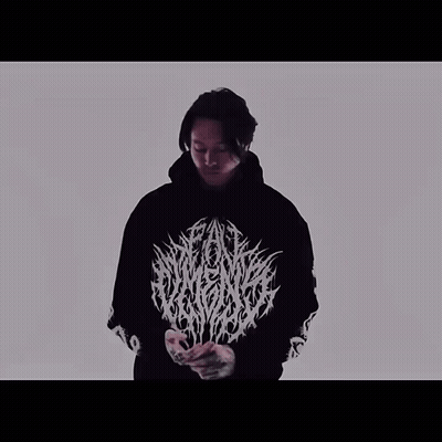 A Man Is Wearing A Black Hoodie With A White Logo On The Front GIF