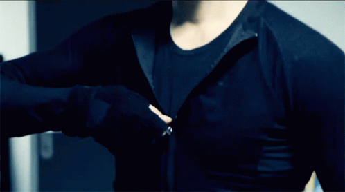 A Man Is Wearing A Black Shirt With A Zipper On The Front GIF