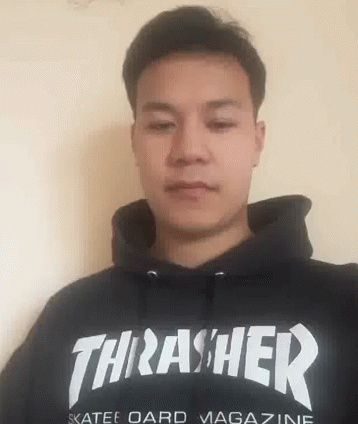 A Man Is Wearing A Black Thrasher Hoodie And Looking At The Camera . GIF
