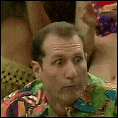 A Man Is Wearing A Colorful Shirt And Making A Surprised Face GIF