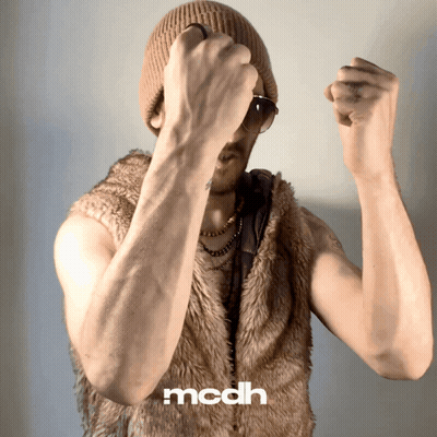 A Man Is Wearing A Fur Vest And A Beanie And The Word Mcdh Is On The Bottom Right GIF