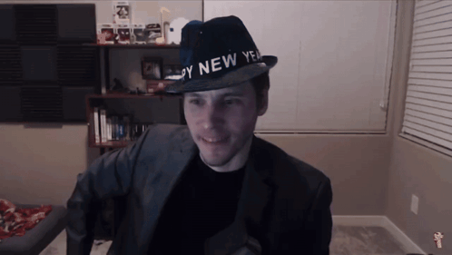 A Man Is Wearing A Hat That Says Happy New Year GIF