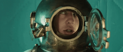 A Man Is Wearing A Helmet With A Hole In It For His Face . GIF