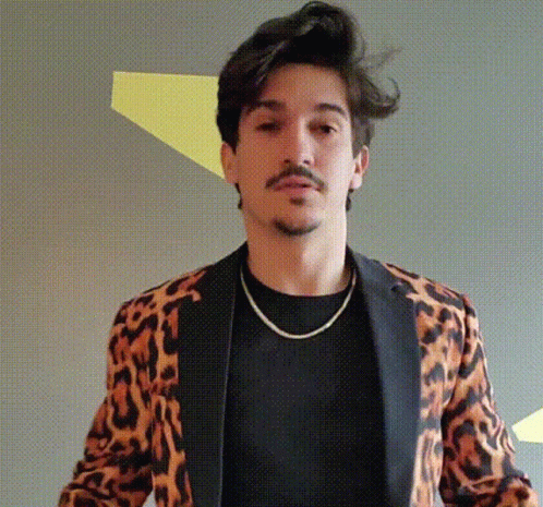 A Man Is Wearing A Leopard Print Jacket And A Black Shirt GIF