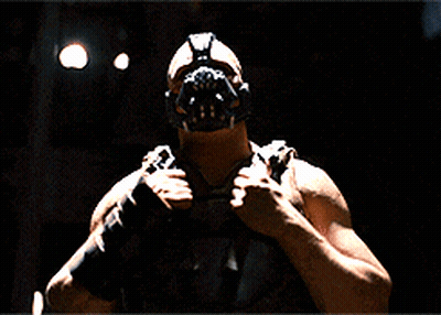 A Man Is Wearing A Mask And Holding A Gun GIF