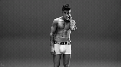 A Man Is Wearing A Pair Of Calvin Klein Underwear With A Black Band Around His Waist . GIF