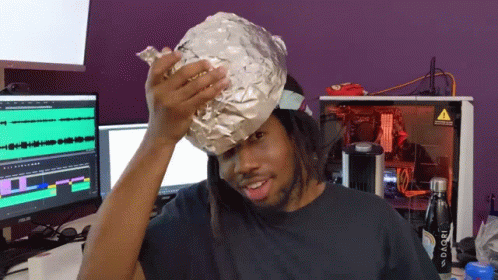 A Man Is Wearing A Potato Wrapped In Tin Foil On His Head GIF
