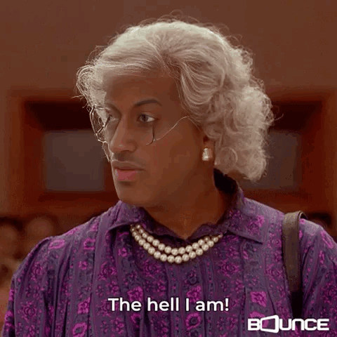 A Man Is Wearing A Purple Shirt And A Pearl Necklace . GIF