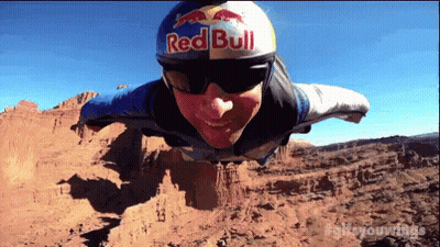 A Man Is Wearing A Red Bull Helmet And Sunglasses GIF