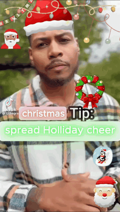 A Man Is Wearing A Santa Hat And A Christmas Wreath GIF