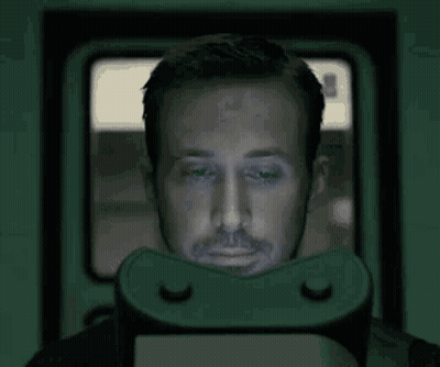 A Man Is Wearing A Virtual Reality Headset And Looking At A Screen . GIF