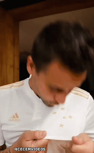 A Man Is Wearing A White Adidas Shirt With Gold Stars On It GIF