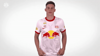 A Man Is Wearing A White Shirt With A Red Bull On It GIF