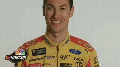 A Man Is Wearing A Yellow And Red Racing Uniform With A Ford Logo On The Front . GIF