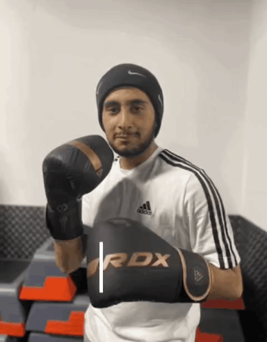 A Man Is Wearing Boxing Gloves That Say Rdx On Them GIF