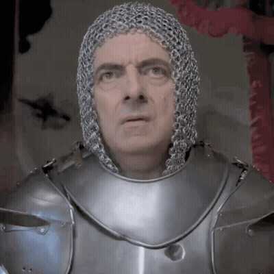 A Man Is Wearing Chain Mail And Armor And Looking At The Camera GIF