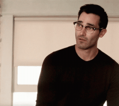 A Man Is Wearing Glasses And A Black Shirt GIF