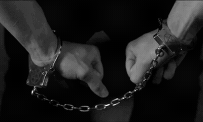 A Man Is Wearing Handcuffs With A Pentagram On Them GIF