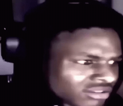 A Man Is Wearing Headphones And Making A Funny Face . GIF