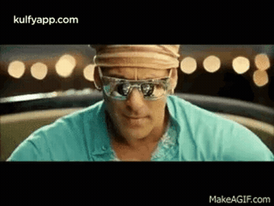 A Man Is Wearing Sunglasses And A Hat While Sitting In A Car . GIF
