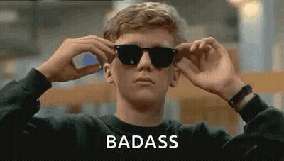 A Man Is Wearing Sunglasses And The Word Badass Is On The Bottom . GIF