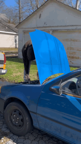 A Man Is Working On A Blue Car With The Hood Up GIF