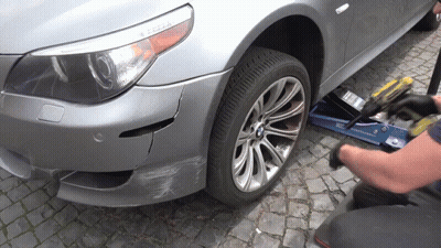 A Man Is Working On A Bmw With A Drill GIF