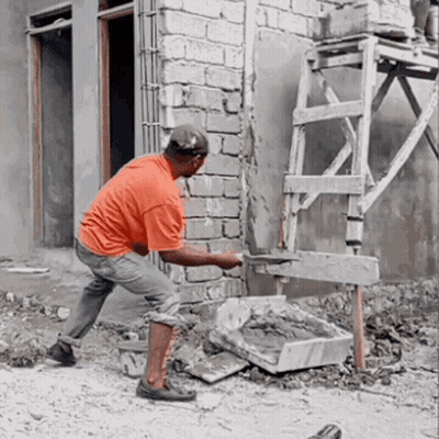 A Man Is Working On A Brick Wall With A Shovel GIF