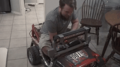 A Man Is Working On A Toy Jeep That Has The Number 001 On The Front GIF
