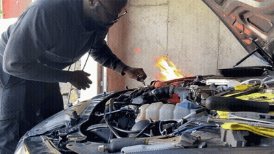 A Man Is Working On The Engine Of A Car GIF