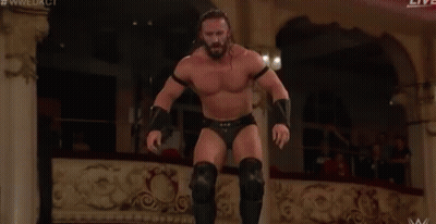 A Man Is Wrestling Another Man In A Ring . GIF