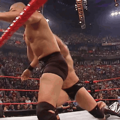 A Man Is Wrestling Another Man In A Wrestling Ring . GIF