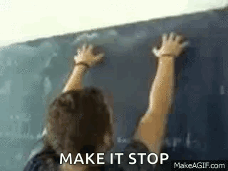 A Man Is Writing On A Blackboard In A Classroom . GIF