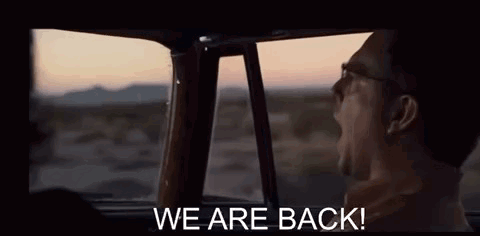 A Man Is Yawning While Sitting In The Back Seat Of A Car With The Words `` We Are Back '' Written On The Screen . GIF