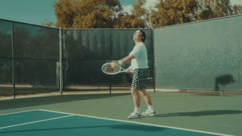 A Man Jumps In The Air While Playing Tennis GIF
