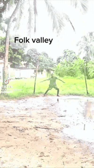 A Man Kicking A Soccer Ball In A Muddy Field With The Words Folk Valley Above Him GIF
