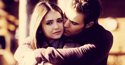 A Man Kisses A Woman On The Forehead While They Hug GIF