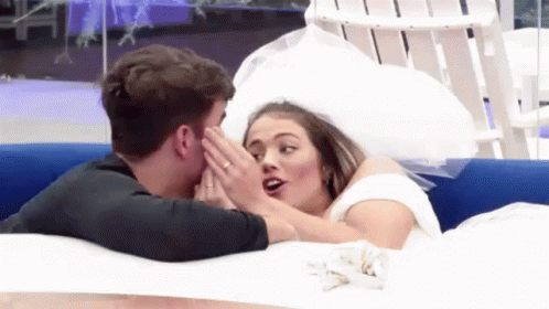 A Man Kissing A Woman In A Wedding Dress In A Pool . GIF