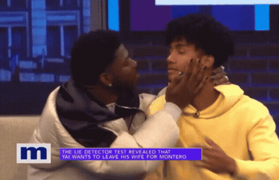 A Man Kissing Another Man On A Tv Show With The Letter M On The Bottom Right GIF