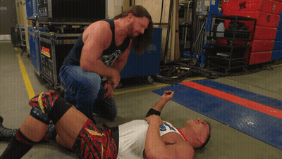 A Man Kneeling Down Next To A Man Laying On The Floor With A Shirt That Says Ohio GIF