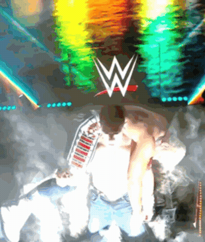 A Man Kneeling In Front Of A Wwe Logo GIF
